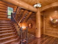 Эксклюзивная лестница из бревен с ковкой в элитном доме из кедра